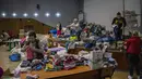 Kesibukan relawan Ukraina saat menyortir pakaian yang disumbangkan untuk kemudian didistribusikan ke penduduk setempat di Lviv, Ukraina barat, pada Rabu (2/3/2022). Invasi Rusia ke Ukraina telah memasuki hari keenam. (AP Photo/Bernat Armangue)