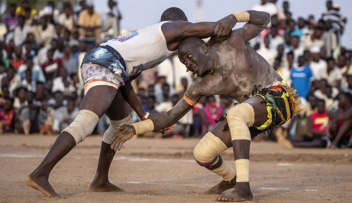 Pegulat tim dari daerah Haj Youssef dan Omdurman bersaing dalam kompetisi gulat tradisional Nuba di Ibu Kota Khartoum, Sudan, 30 Juli 2021. (Abdulmonam EASSA/AFP)
