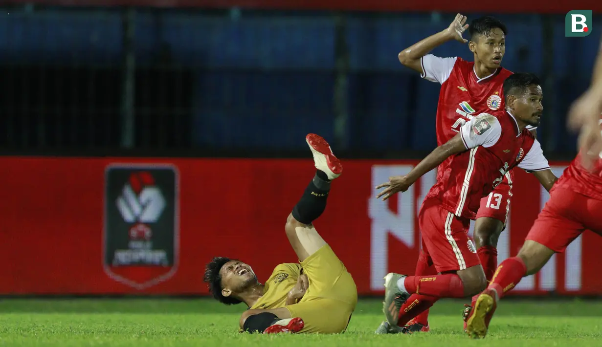 Gelandang Bhayangkara Solo FC, Andik Vermansah (kiri), terjatuh usai dijatuhkan pemain Persija Jakarta pada laga Piala Menpora 2021 di Stadion Kanjuruhan, Malang, Rabu (31/3/2021). Persija Menang dengan skor 2-1. (Bola.com/M Iqbal Ichsan)