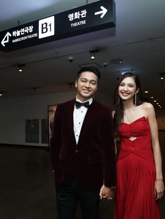 Penampilan pemain film Cinta Laki-Laki Biasa itu makin gagah saat bersanding dengan Mikha Tambayong. Sang kekasih sendiri mengenakan gaun panjang bernuansa merah cerah. (Liputan6.com/IG/@devamahenra).