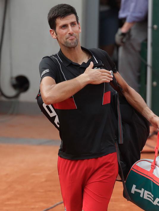 Petenis Serbia, Novak Djokovic meninggalkan lapangan seusai kalah dari petenis Italia Marco Cecchinato pada perempatfinal Prancis Terbuka 2018, Selasa (5/6). Djokovic dikalahkan petenis non-unggulan dalam duel empat set. (AP/Alessandra Tarantino)