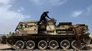 Seorang teknisi militer Pasukan Mobilisasi Populer Irak (Hashid Shaabi) mengecek tank yang rusak di sebuah bengkel di Kerbala, Irak (7/5). Bengkel ini menjadi salah satu lokasi perbaikan kendaraan-kendaraan militer rusak usai dipergunakan untuk perang. (Reuters/Abdullah Dhiaa Al- Dien)