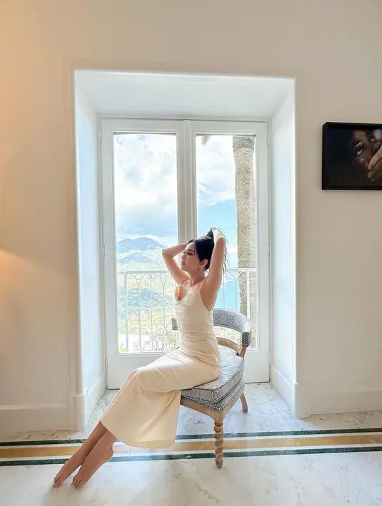 Dress putih polos elegan membalut tubuh Shandy Aulia dengan sangat baik. Penampilan elegan tanpa tambahan aksesori berlebihan, lihat body goals ala Shandy Aulia di sini. Foto: Instagram.