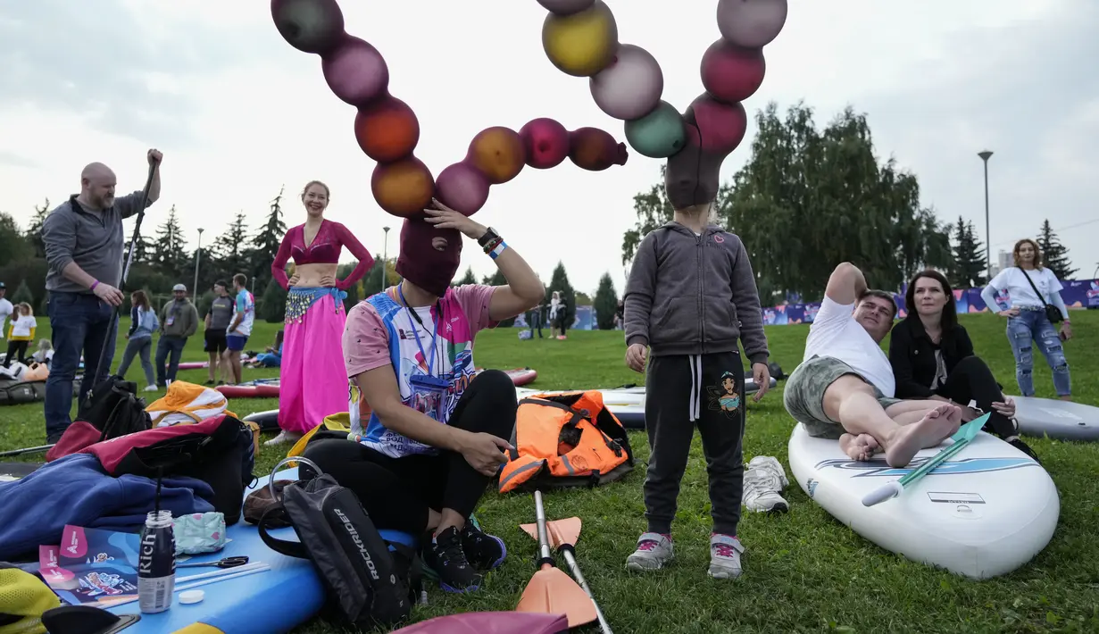Peserta bersiap untuk memulai festival dayung berdiri (stand up paddle) di kanal dayung Olimpiade Krylatskoye, Moskow, Rusia, Minggu (12/9/2021). Festival dihadiri para peserta dalam balutan kostum warna-warni yang menggambarkan aneka karakter dalam tokoh film. (AP/Pavel Golovkin)