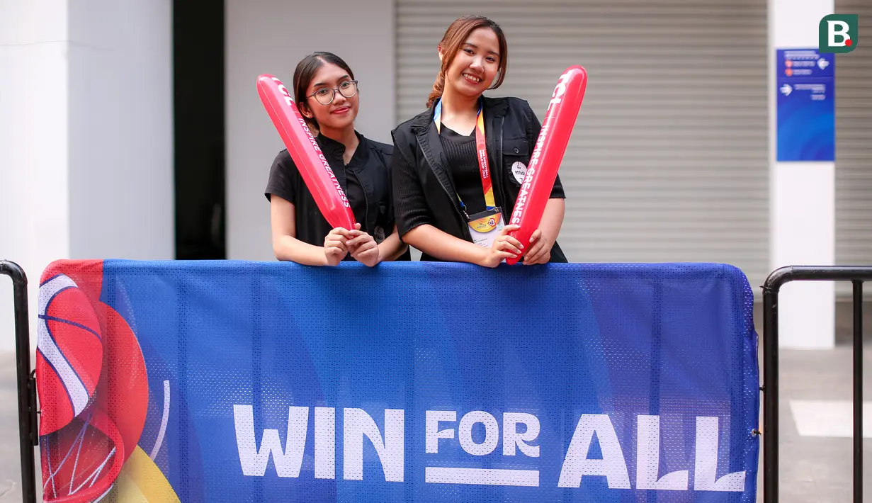 Chelsy Dea Abigail Tampubolon (kiri) dan Evelyn Deborah Inly merupakan dua remaja wanita yang bertugas sebagai penyambut penonton di luar Indonesia Arena selama Piala Dunia FIBA 2023. Tugas mereka untuk menyapa, menyambut, hingga mengarahkan penonton menuju ticket box dan merchandise. Chelvy dan Evelyn sendiri merupakan mahasiswi. (Bola.com/Bagaskara Lazuardi)