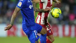 Bek Atletico Madrid, Kieran Trippier berebut bola dengan bek Getafe, Mathias Olivera pada laga pekan keenam Liga Spanyol di Stadion Coliseum Alfonso Perez, Rabu (22/9/2021) dini hari WIB. Luis Suarez memborong dua gol saat Atletico Madrid mengalahkan Getafe 2-1. (AP Photo/Manu Fernandez)