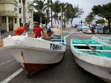 Para nelayan memindahkan perahu mereka yang biasanya berlabuh di Teluk Meksiko, ke pinggir jalan di pelabuhan kota Veracruz, Rabu (9/8). Meksiko bersiap menghadapi kedatangan Franklin, yang berubah menjadi badai dengan Kategori 1. (AP/Felix Marquez)