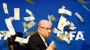 Komedian Inggris, Lee Nelson melempar uang kertas ke arah Sepp Blatter di markas FIFA di Zurich, Swiss (20/7/2015). Kedatangan Nelson membuat jumpa pers tertunda beberapa saat. (REUTERS/Arnd Wiegmann)