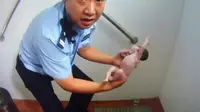 Polisi mengevakuasi bayi dari toilet umum di Beijing, China. (AFP/Daily Mail)