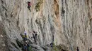 Peserta berusaha memanjat tebing dalam Festival Mendaki tahunan 2019 di pulau Kalymnos, Yunani (4/10/2019). Pemandangan menakjubkan dan cuaca bagus menjadikan pulau ini sebagai tujuan utama bagi pemanjat dari semua tingkatan dengan lebih dari 2500 rute pendakian. (AFP Photo/Aris Messinis)