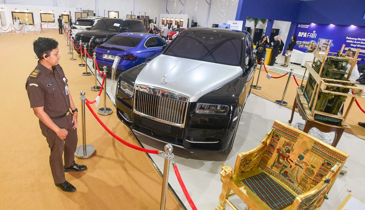Petugas mengamati mobil mewah yang siap dilelang terbuka pada acara Badan Pemulihan Aset (BPA) Kejaksaan Agung Fair 2026 di Jakarta, Kamis (21/5/2026). (merdeka.com/Arie Basuki)