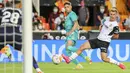 Gelandang Real Madrid, Federico Valverde mencoba melakukan tembakan di sebelah bek Valencia, Toni Lato pada lanjutan La Liga di Stadion Mestalla, Senin (20/9/2021) dini hari WIB. Real Madrid menang 2-1 secara dramatis atas Valencia. (AP Photo/Alberto Saiz)