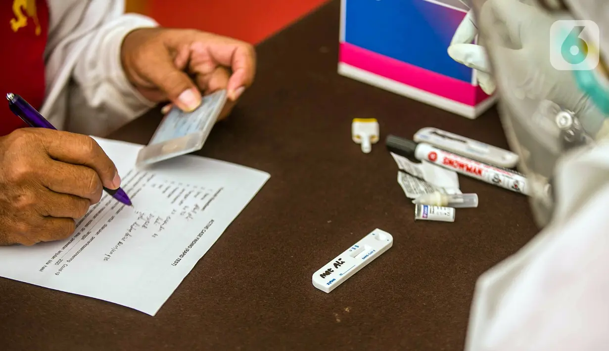 Warga mengisi formulir saat mengikuti rapid test gratis di Pos Pengamanan Natal 2020 dan Tahun Baru 2021 Polsek Kebayoran Lama, Jakarta, Selasa (29/12/2020). Rapid test itu dilakukan untuk membantu mengurai antrean warga saat tes di tempat lainnya. (Liputan6.com/Faizal Fanani)