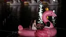 Seorang wanita dan anak bersantai di atas balon Flamingo di Danau Sarah Kubstichek saat mereka menonton film selama Festival Terapung di Brasilia, Brasil (30/9/2020). Konsep apung menjadi tren baru saat pandemi di beberapa negara seperti Israel dan Meksiko.  (AP Photo/Eraldo Peres)