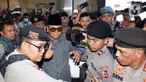 Pemimpin Pondok Pesantren Al Zaytun Panji Gumilang (kopiah hitam) mengacungkan jempol saat tiba di Bareskrim Polri, Jakarta, Selasa (1/8/2023). Panji Gumilang memenuhi panggilan pemeriksaan penyidik Direktorat Tindak Pidana Umum Bareskrim Polri terjait dugaan penistaan agama. (Liputan6.com/Herman Zakharia)