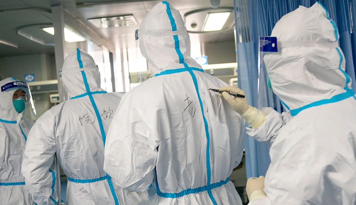 Seorang pekerja medis menulis nama rekan mereka pada baju pelindung untuk membantu identifikasi menyusul wabah virus corona di Rumah Sakit Zhongnan, Wuhan University, Wuhan, Provinsi Hubei, China, Jumat (24/1/2020). Penemuan virus corona pertama kali diungkapkan oleh dr Li Wenliang. (Xiong Qi/Xinhua