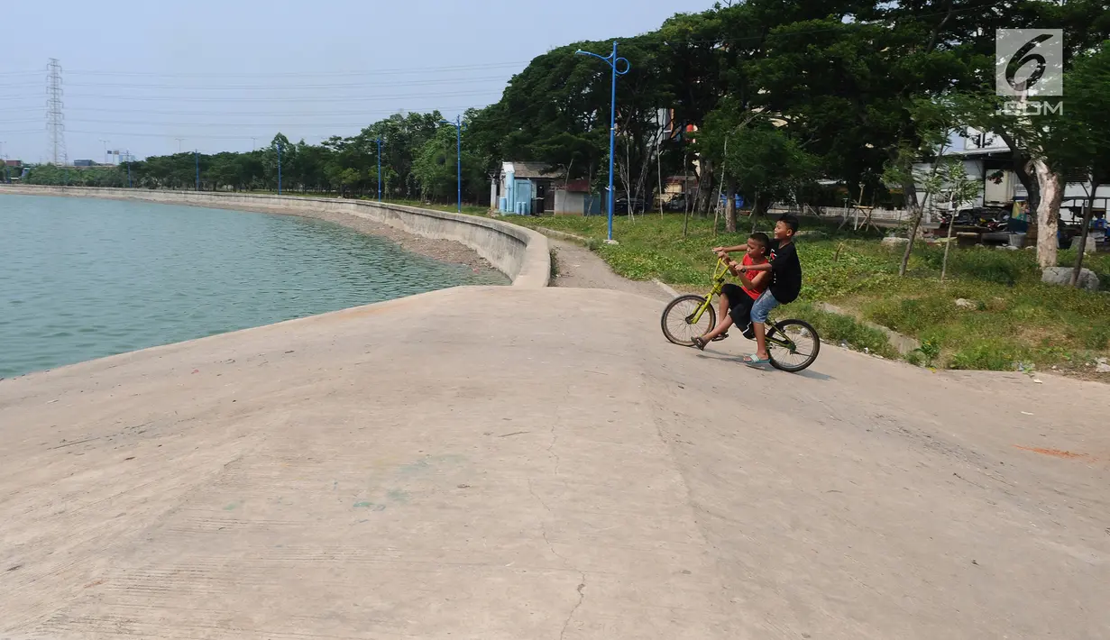 Anak-anak bermain sepeda di Waduk Cincin, Jakarta, Selasa (8/1). Pemerintah Kota Administratif Jakarta Utara berencana menata kawasan Hutan Kota Waduk Cincin yang berlokasi di kawasan Sunter, Jakarta Utara. (Liputan6.com/Herman Zakharia)