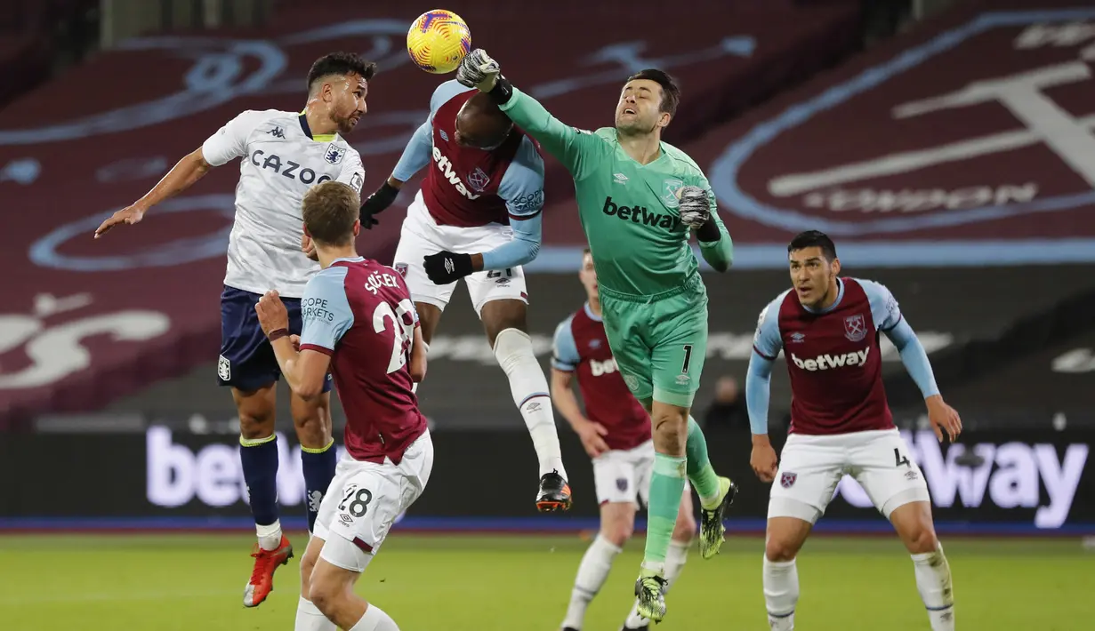 Kiper West Ham United, Lukasz Fabianski, menepis bola saat menghadapi Aston Villa pada laga lanjutan Liga Inggris di Stadium of London, Selasa (1/12/2020) dini hari WIB. West Ham menang 2-1 atas Aston Villa. (AFP/Frank Augstein/pool)