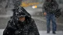 Pejalan kaki menghadapi hujan salju yang turun di Manhattan, New York, Kamis (15/11). Salah satu badai besar pertama musim ini bergerak melintasi bagian timur negara tersebut pada Kamis ini. (AP/Bebeto Matthews)