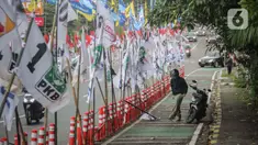 Ratusan bendera parpol terpasang di tiang plastik pembatas jalur sepeda (stick cone) di Jalan Rasuna Said, Jakarta, Senin (8/1/2024). (Liputan6.com/Angga Yuniar)