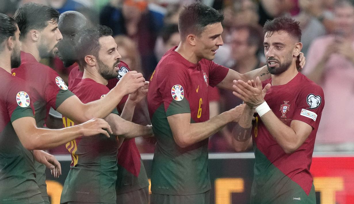Timnas Portugal sukses meraih tiga poin penuh setelah menghajar Bosnia Herzegovina 3-0 pada laga matchday ketiga Grup J Kualifikasi Euro 2024 di Luz Stadium, Lisbon, Portugal, Minggu (18/6/2023) dini hari WIB. Dua pemain yang mentas bersama klub asal Manchester, Bernardo Silva (Manchester City) dan Bruno Fernandes (Manchester United) menjadi bintang kemenangan dalam laga tersebut. Bernardo Silva menyumbang satu gol, sementara Bruno Fernandes berjasa mencetak dua gol dan satu assist. Dengan hasil ini Portugal sementara kukuh di puncak klasemen Grup J dengan 9 poin hasil dari sapu bersih 3 kemenangan dalam 3 laga. (AP Photo/Armando Franca)