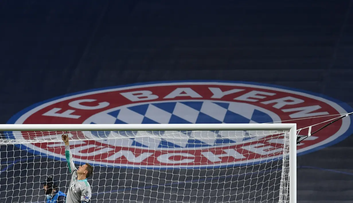 Kiper Bayern Munchen, Manuel Neuer memotong jaring gawang saat merayakan timnya meraih trofi Liga Champions usai mengalahkan PSG pada pertandingan final di stadion Luz di Lisbon (23/8/2020). Munchen menang tipis atas PSG 1-0. (AFP/Pool/David Ramos)