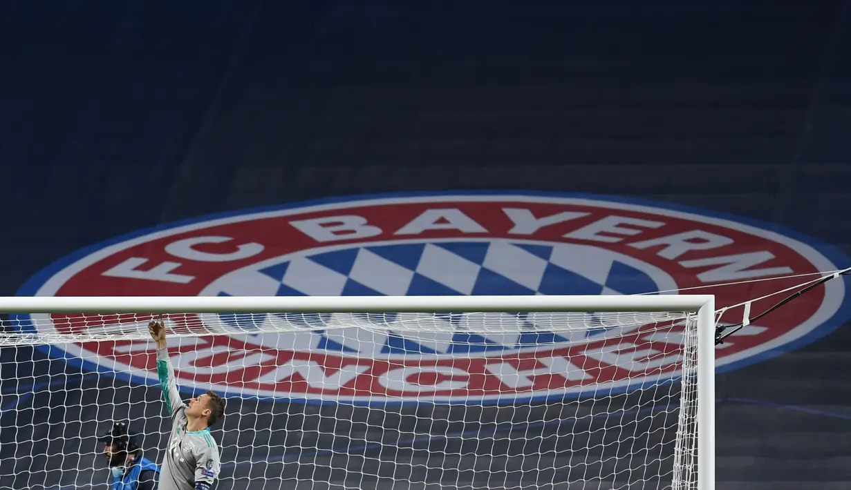 Kiper Bayern Munchen, Manuel Neuer memotong jaring gawang saat merayakan timnya meraih trofi Liga Champions usai mengalahkan PSG pada pertandingan final di stadion Luz di Lisbon (23/8/2020). Munchen menang tipis atas PSG 1-0. (AFP/Pool/David Ramos)