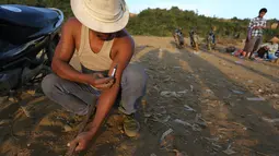 Penambang menyuntikan heroin di Tambang batu giok di Hpakant, Myanmar, 29 November 2015. Kecanduan narkotika sudah merabak pada penambang batu giok untuk digunakan dengan alasan agar kuat mencari dan menemukan gumpalan batu mulia. (REUTERS/Soe Zeya Tun)