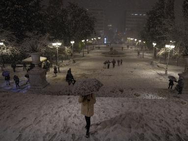 Orang-orang saling melempar bola salju di taman yang tertutup salju di Istanbul, Turki, Senin (24/1/2022). Badai salju yang parah mengganggu lalu lintas jalan dan udara pada Senin di ibu kota Yunani, Athena dan di kota tetangga terbesar di Turki, Istanbul. (AP Photo/Emrah Gurel)