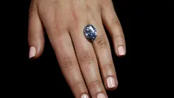 Seorang petugas sedang melihat berlian biru 10,10 karat di rumah lelang sothbey, London, Inggris, Selasa (15/3). Berlian berbentuk oval ini akan dilelang di Magnificent Jewels dan Jadeite Hongkong pada 5 April 2016. (REUTERS / Stefan Wermuth)
