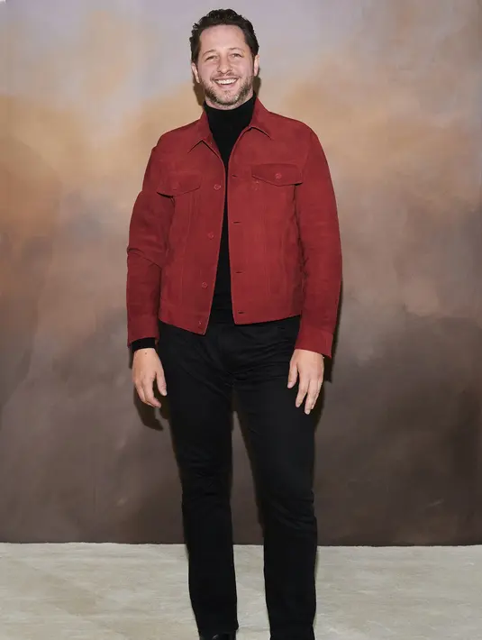 Derek Blasberg juga tampil menawan dengan sweater turtleneck hitam yang dilayer dengan double-breasted jacket berwarna merah bata, dipadunya dengan celana jeans hitam, dan sepatu hitam. Foto: Document/Louis Vuitton.
