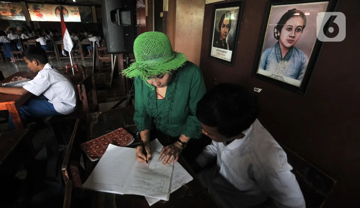 Sri Irianingsih memberikan materi pengajaran di Sekolah Darurat Kartini, kawasan Lodan, Jakarta Utara, Senin (25/11/2019). Sri Rossyati dan Sri Irianingsih berharap mampu terus memberikan pendidikan berkualitas yang bisa merubah masa depan anak-anak menjadi lebih baik. (merdeka.com/Iqbal Nugroho)