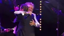 Rod Stewart merangkul Jools Holland pada konser amal untuk membantu kanker prostat Raise the Roof yang diselenggarakan oleh Jools Holland di Royal Albert Hall, London, Inggris, 22 Juni 2022. Rod Stewart sendiri sebelumnya berjuang melawan penyakit kanker prostat, namun kini telah mengalami remisi. (Suzan Moore/PA via AP)