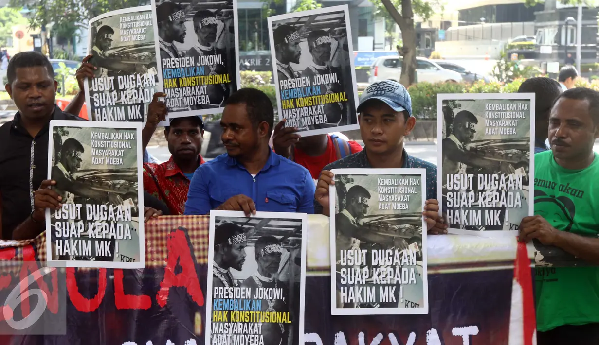 Warga Papua membawa beragam poster saat aksi di depan KPK, Jakarta, Senin (2/5). Mereka meminta KPK mengusut dugaan suap hakim MK di sengketa pilkada Teluk Bintuni (Liputan6.com/Helmi Afandi)