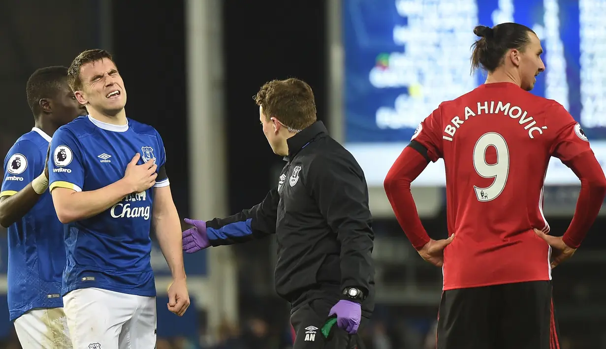 Pemain Everton, Seamus Coleman (2 kiri) terlihat kesakitan usai bertabrakan dengan Zlatan Ibrahimovic pada laga Premier League di Goodison Park, Liverpool, (04/12/2016). MU bermain imbang 1-1 lawan Everton. (AFP/Paul Ellis)