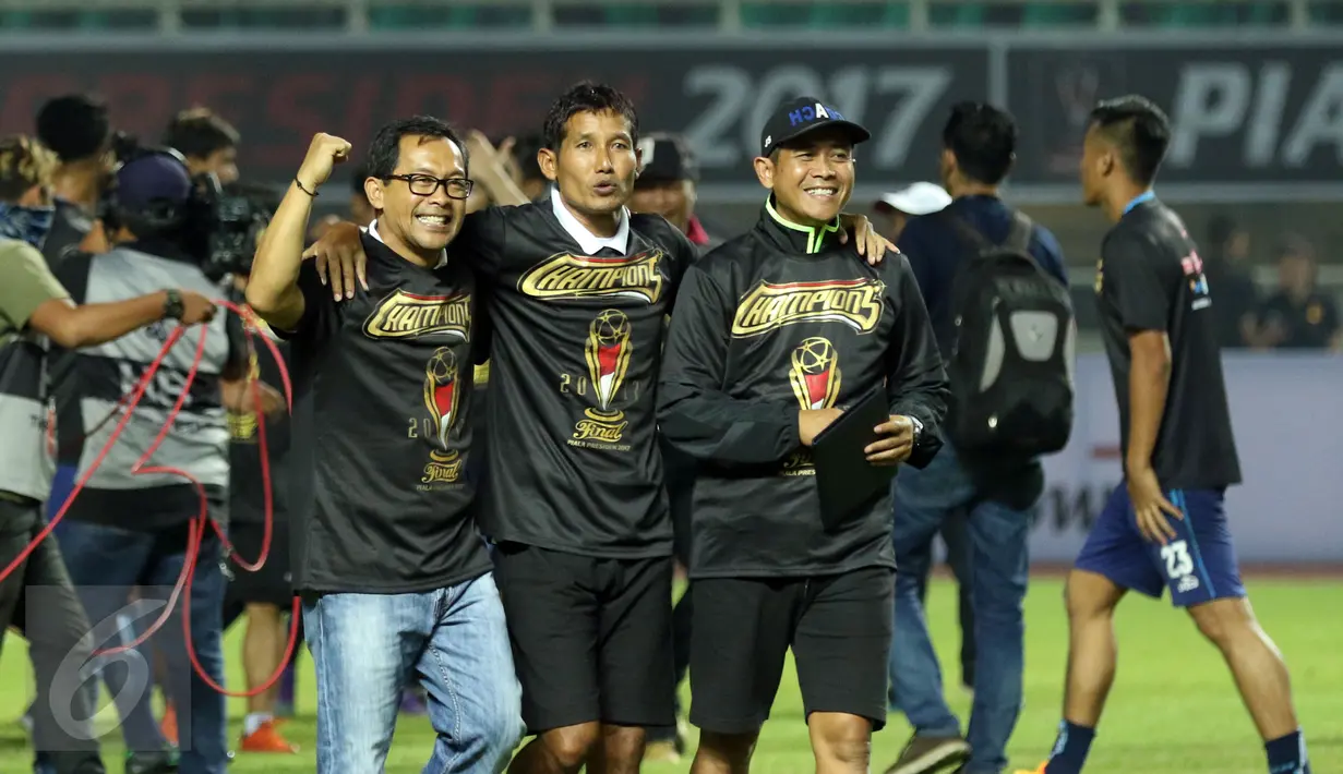 Pelatih Arema FC, Aji Santoso (kiri) merayakan kemenangan atas PBFC di laga final di Stadion Pakansari, Kab Bogor, Minggu (12/3). Arema menang 5-1 dan berhasil merengkuh trofi Piala Presiden. (Liputan6.com/Helmi Fithriansyah) 