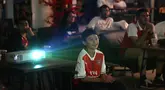 Seorang penggemar muda Arsenal terlihat tersenyum gembira saat menyaksikan tim kebanggaannya unggul lima gol melawan Burnley di Liga Premier.  (Bola.com/M Iqbal Ichsan)
