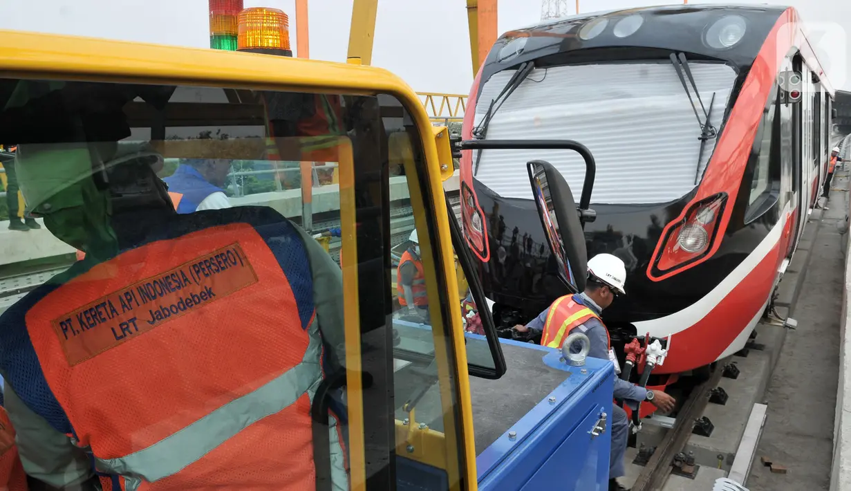 Pekerja menderek rangkaian kereta LRT Jabodebek yang baru tiba di Stasiun Harjamukti, Cibubur, Minggu (13/10/2019). Pengiriman prasarana gerbong LRT produksi PT INKA ke Jakarta dilakukan melalui jalur Tol Trans Jawa dan diangkut menggunakan multi-axle. (merdeka.com/Iqbal S Nugroho)