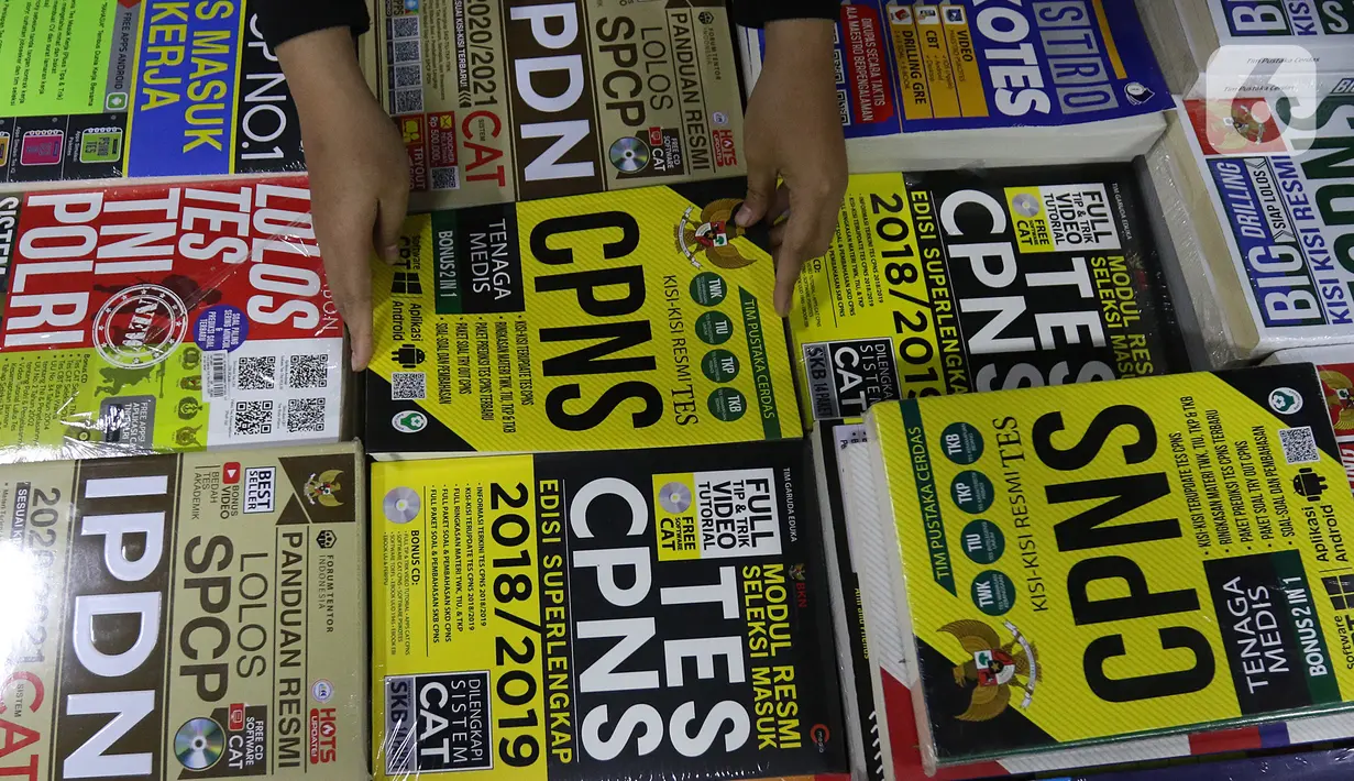 Pekerja merapikan buku di Pasar Kenari, Jakarta, Kamis (28/11/2019). Buku panduan lolos tes yang dijual mulai dari Rp 88.000 hingga Rp 195.000 per eksemplar menjadi barang yang paling dicari dan diminati jelang pelaksanaan tes CPNS. (Liputan6.com/Herman Zakharia)