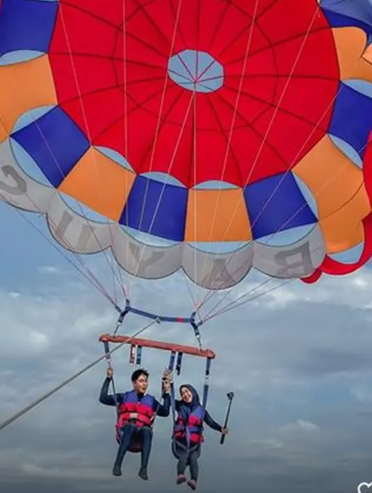 Ria Ricis dan Teuku Ryan rupanya senang menjajal wahana ekstrem. Keduanya juga naik Parasailing dengan pemandangan laut yang indah. Meski berada di ketinggian, mereka sangat begitu bahagia tanpa rasa takut. (Liputan6.com/IG/@riaricis1795)