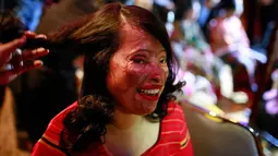 Seorang wanita korban serangan cairan asam dirias sebelum tampil pada pagelaran busana "Beauty Redefined" di Dhaka, Bangladesh, 7 Maret 2017. Pagelaran fesyen tak biasa ini dihadiri oleh pecinta fesyen, diplomat, termasuk utusan AS.  (AP Photo/A. M. Ahad)