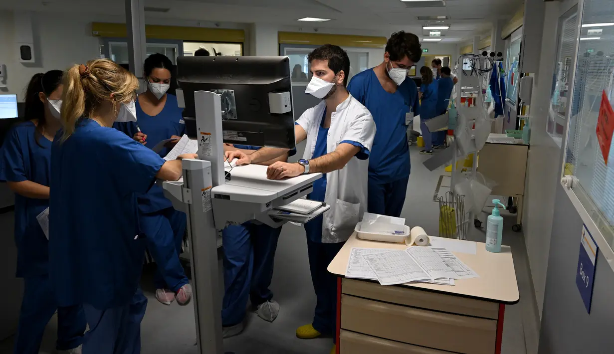 Seorang dokter (kedua kanan) berbicara dengan perawat tentang pasien Covid-19 di unit perawatan intensif rumah sakit Timone, di Marseille, Rabu (5/1/2022). Prancis mencatat rekor kasus baru Covid-19 dalam sehari pada Rabu waktu setempat dengan 335.000 tambahan kasus baru infeksi. (Nicolas TUCAT/AFP)