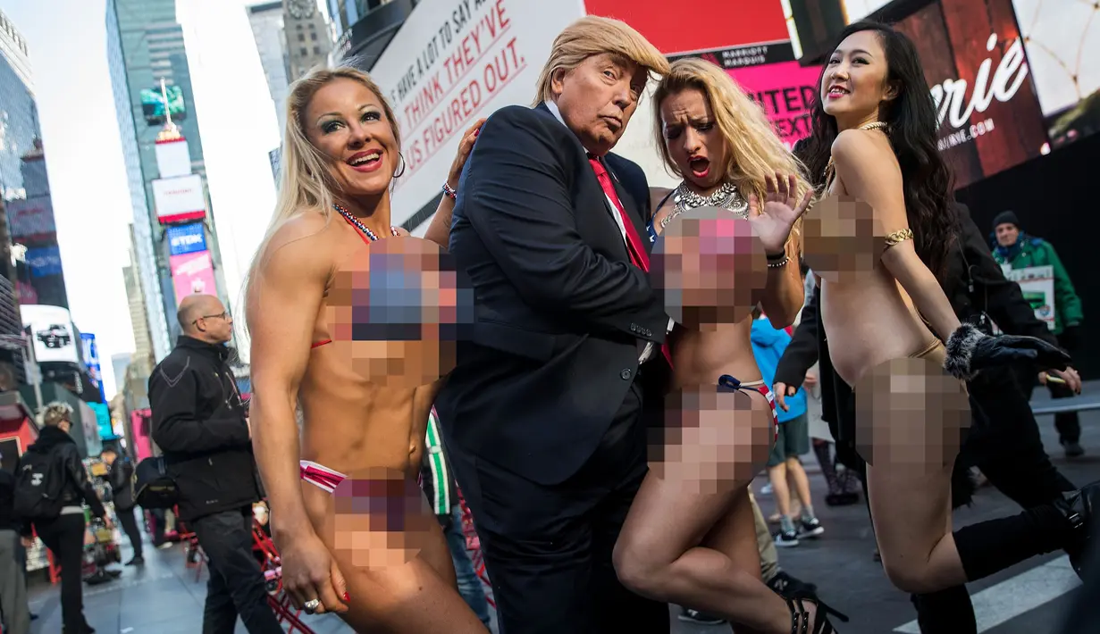 Seorang seniman berpenampilan seperti Donald Trump meraba-raba wanita seksi berbikini saat berada di depan Trump Tower di New York, 25 Oktober 2016. (AFP Photo/Drew Angerer/Getty Images)