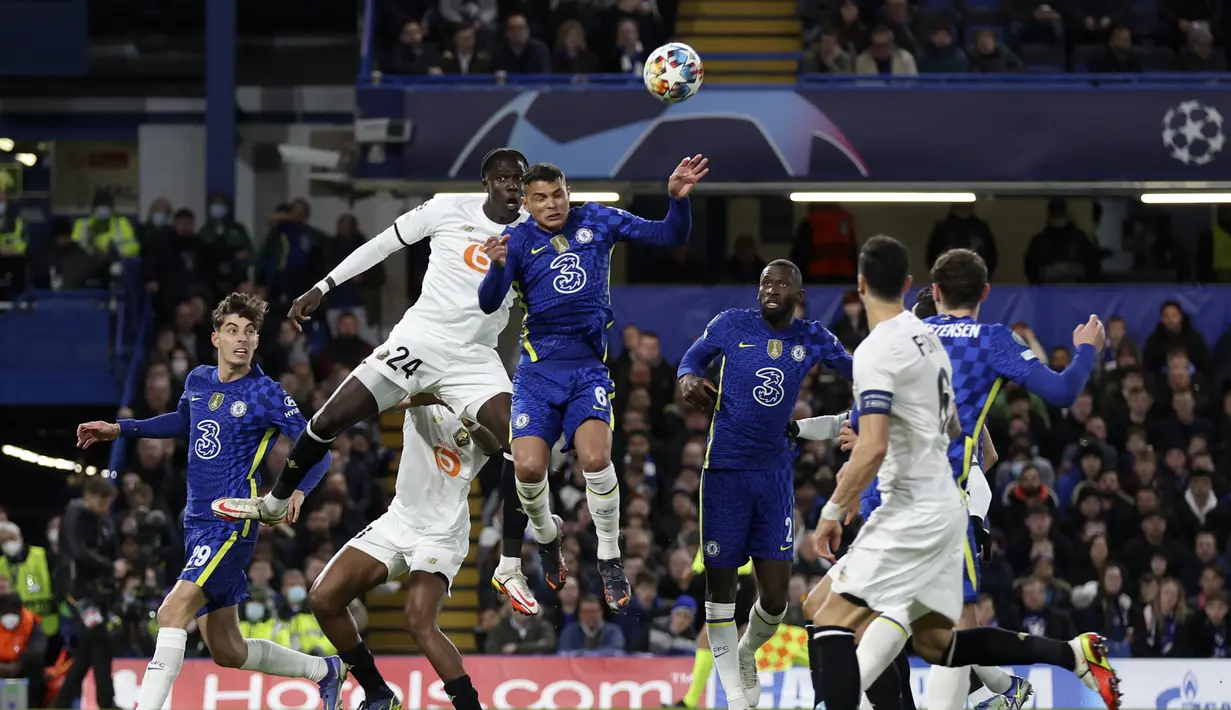 Bek Chelsea, Thiago Silva (tengah) berebut bola udara dengan pemain Lille, Amadou Onana (kiri)  pada pertandingan leg pertama Liga Champions di Stamford Bridge, London, Rabu (23/2/2022). Chelsea menang atas Lille 2-0. (AP Photo/Ian Walton)