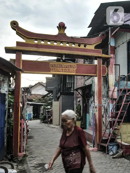 Warga lansia melintas di depan gerbang Kampung Tehyan, Tangerang, Banten, Selasa (9/2/2021). Cina Benteng adalah sebutan untuk komunitas Tionghoa di Tangerang yang penampilan fisiknya sudah tak tampak seperti orang Cina. (merdeka.com/Iqbal S. Nugroho)