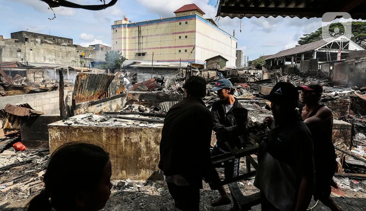 Warga memilah barang pasca terjadi kebakaran di Pasar Ciputat, Tangerang Selatan, Kamis (12/5/2022). Puluhan lapak pedagang di Pasar Ciputat, Kota Tangerang Selatan (Tangsel), Banten terbakar pada Rabu (11/5/2022) sore. Kebakaran diduga terjadi akibat adanya arus pendek atau korsleting listrik. (Liputan6.com/Johan Tallo)