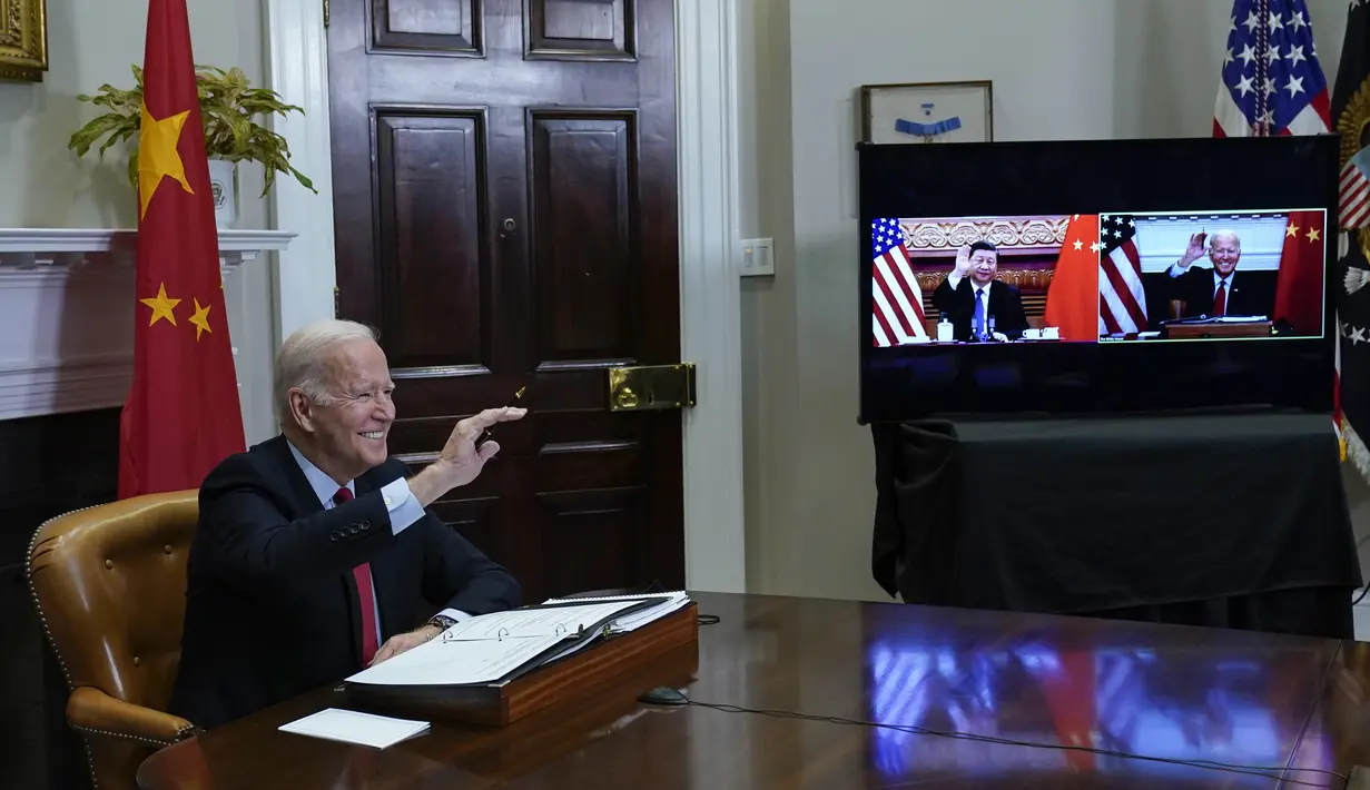 Presiden Joe Biden melambai saat bertemu secara virtual dengan Presiden China Xi Jinping dari Ruang Roosevelt Gedung Putih di Washington, Senin (15/22/2021). Pertemuan dimaksudkan untuk menurunkan ketegangan antara AS dan China selaku dua negara adidaya dunia saat ini. (AP Photo/Susan Walsh)