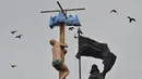 Seorang pria memanjat tiang kayu selama perayaan Maslenitsa di kota Krasnoyarsk, Rusia, (13/3). perayaan Maslenitsa adalah kegiatan untuk menandai berakhirnya musim dingin di Rusia. (REUTERS/Yuri Maltsev)