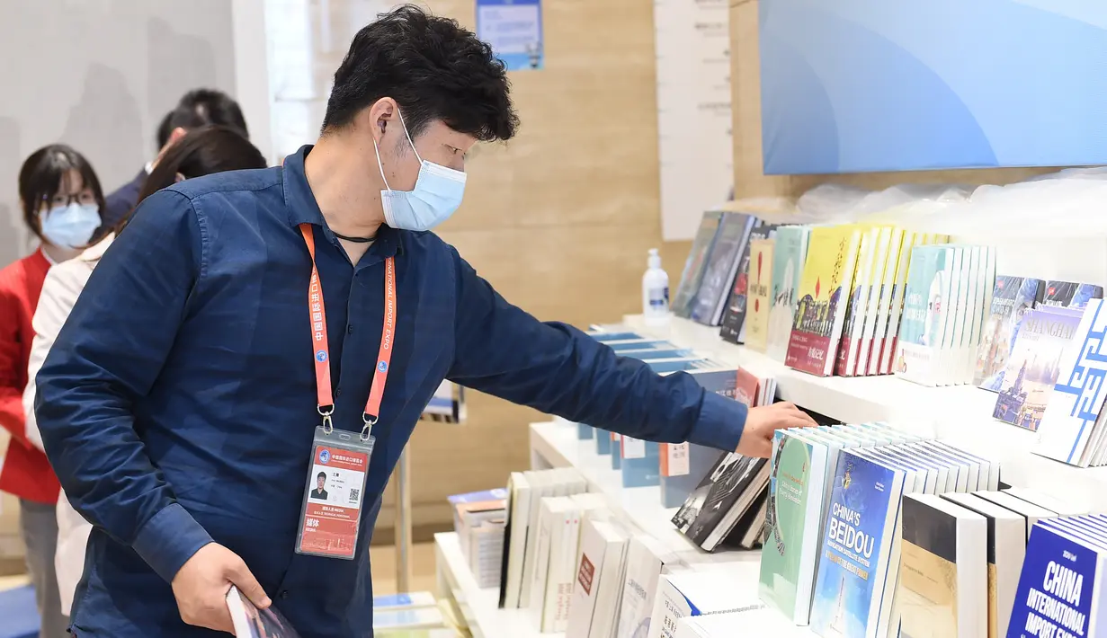 Seorang reporter memilih buku di media center Pameran Impor Internasional China (China International Import Expo/CIIE) ketiga di Shanghai, China timur, pada 3 November 2020. (Xinhua/Zhao Dingzhe)