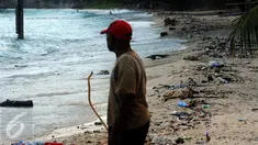 Warga melihat kondisi pantai Pasir Putih, Manokwari, Papua Barat yang dipenuhi sampah, Senin (15/8/2016). Kondisi ini bisa mengurangi daya tarik wisatawan lokal maupun mancanegara menikmati keindahan alam Papua Barat. (Liputan6.com/Helmi Fithriansyah)